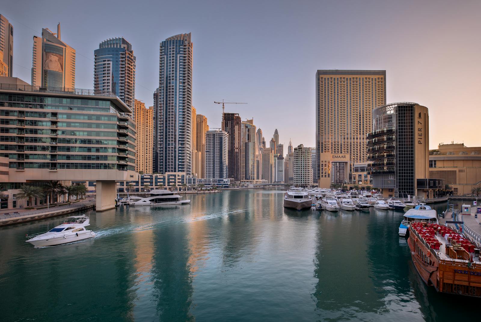 Scenic view of Dubai Marina with modern skyscrapers and yachts at dusk.
