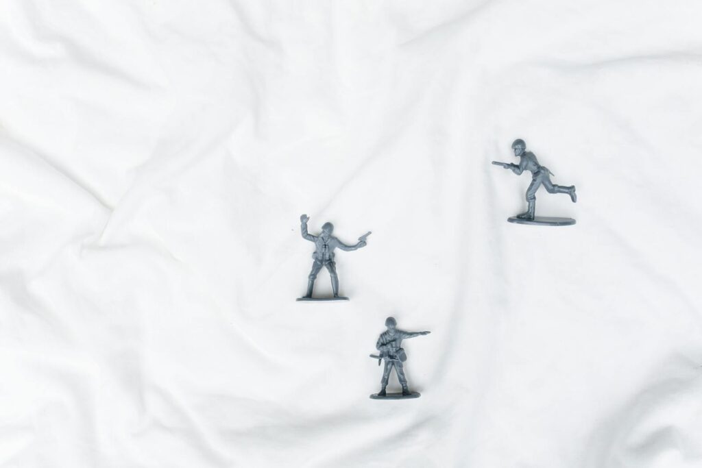 Plastic toy soldiers arranged creatively on a white background, offering ample copy space.